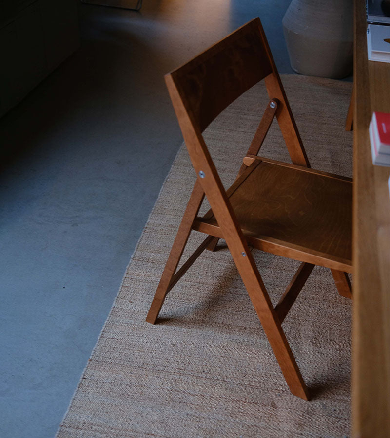 Frama Folding Flat Chair designet av Casegoods ved Kollekted by en interiørforretning på Grunerløkka i Oslo. Klapptolen er i Warm Brown